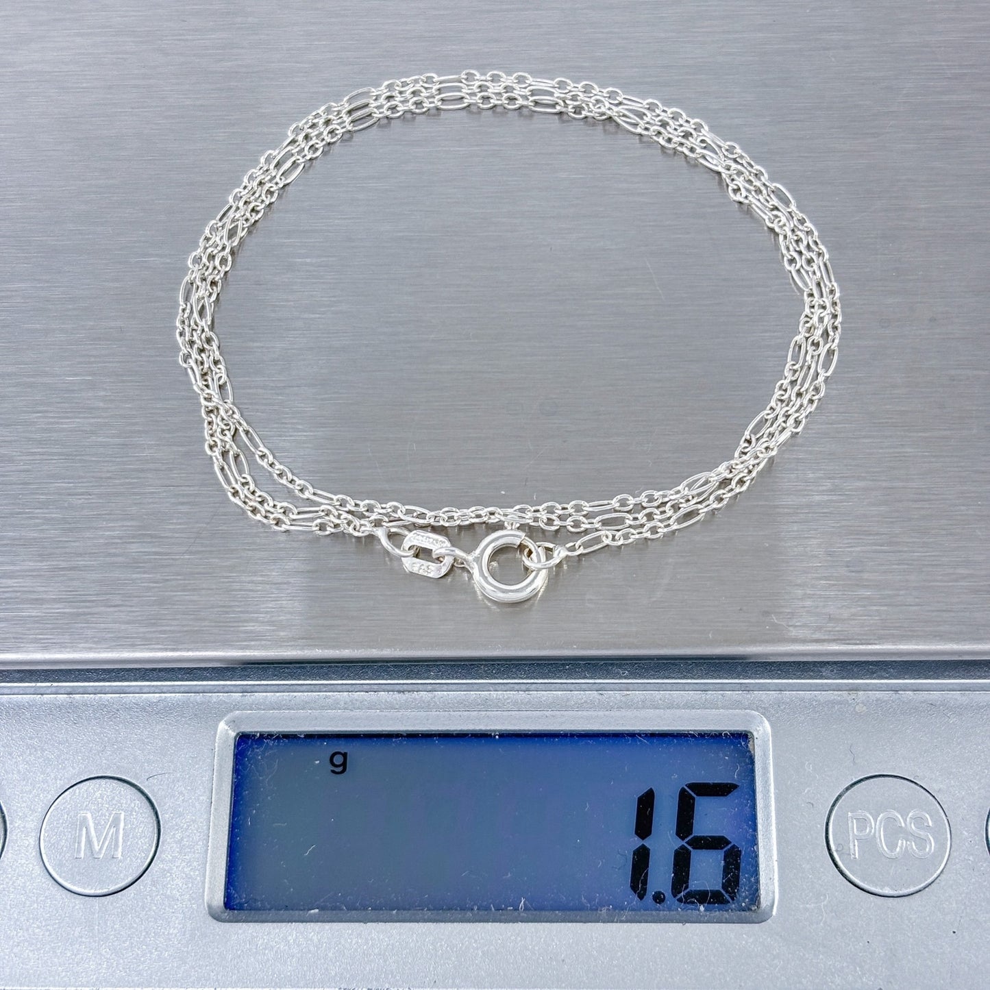 Silver bracelet on a digital scale displaying a weight of 16 grams.