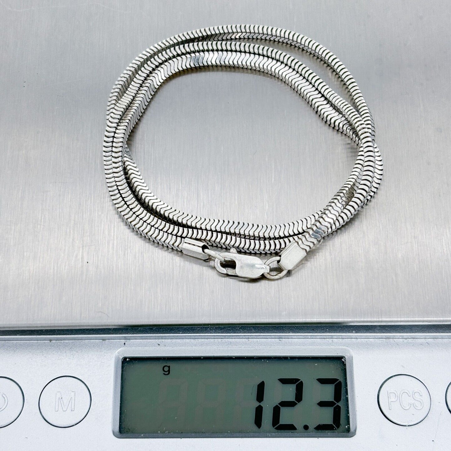 Silver chain necklace on a digital scale displaying weight