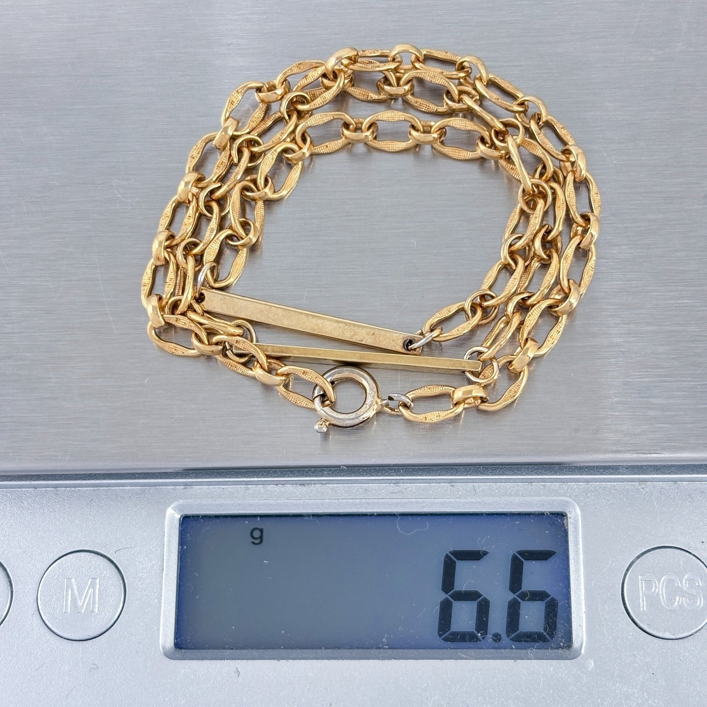 Gold chain on a digital scale displaying a weight of 6.6 grams.