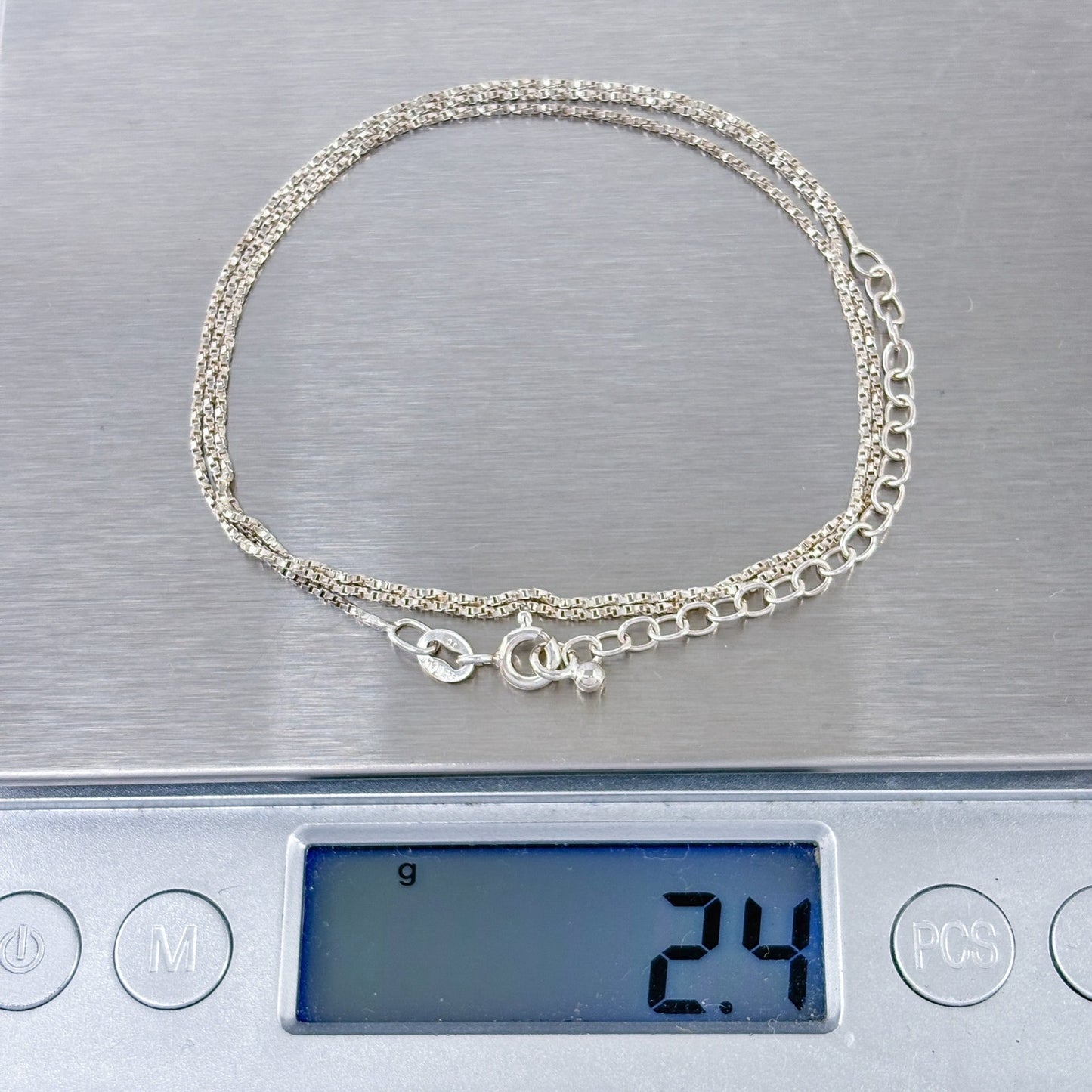 Silver bracelet on a digital scale displaying weight