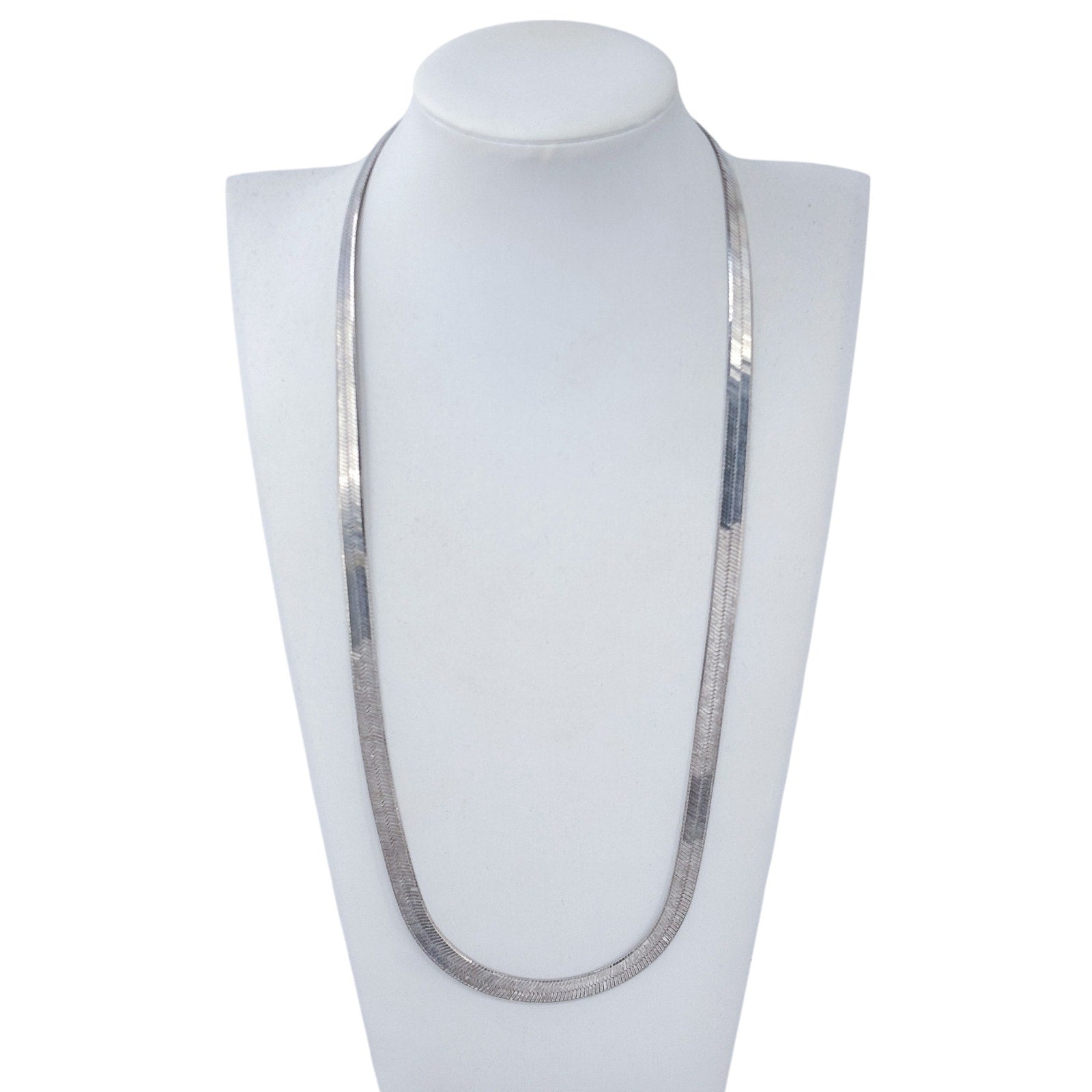 Silver necklace on a white mannequin bust