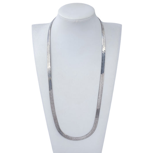 Silver necklace on a white mannequin bust
