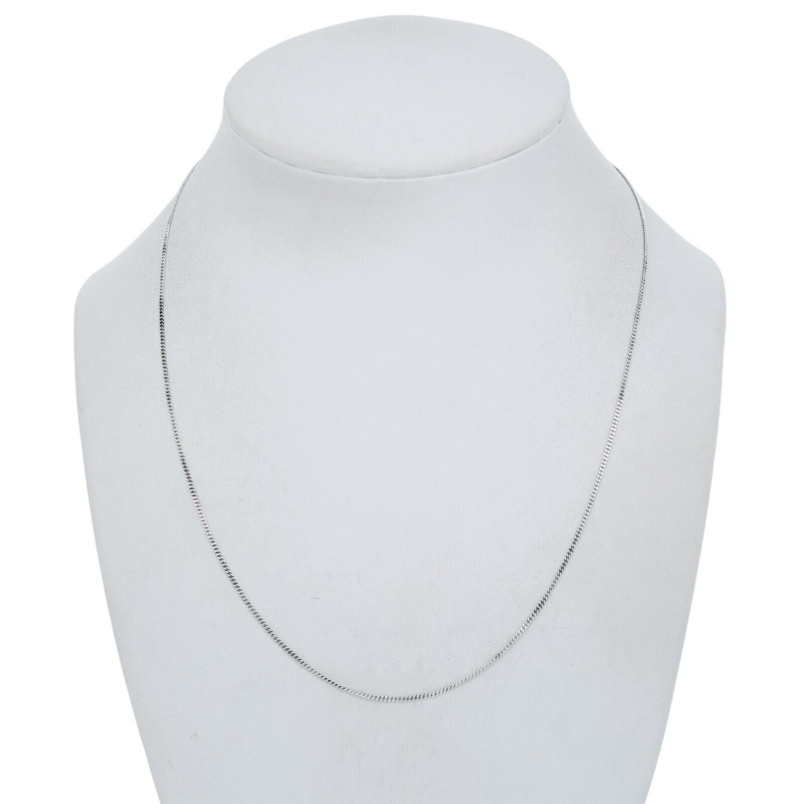 Silver necklace on a mannequin bust against a white background