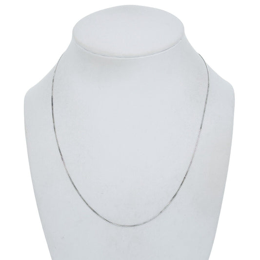 Silver necklace on a mannequin bust against a white background