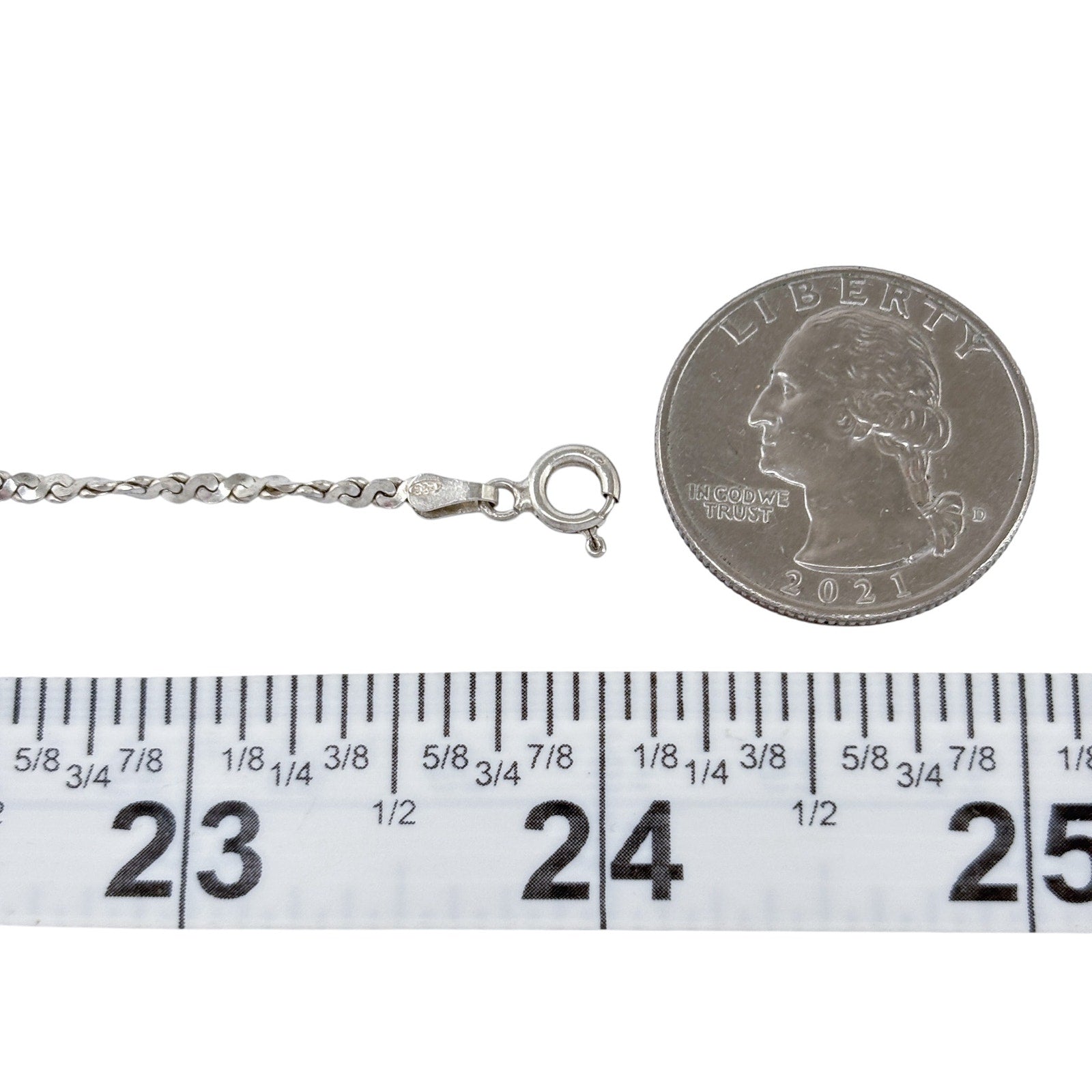Silver serpentine necklace with clasp and chain, shown next to a quarter and ruler for size reference.
