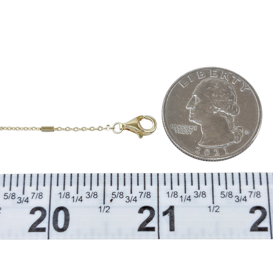 Gold necklace with clasp next to a quarter and ruler for measurement on a white background