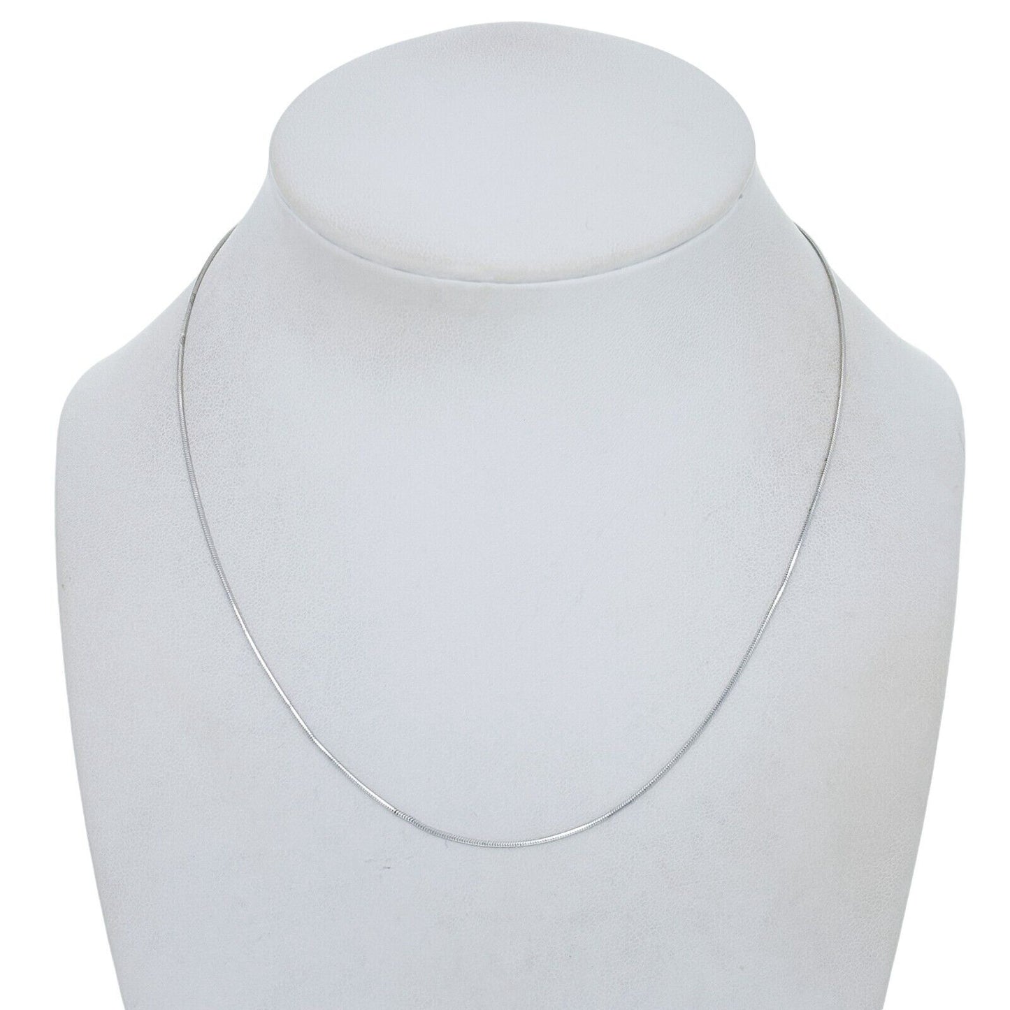Silver necklace on a mannequin bust against a white background