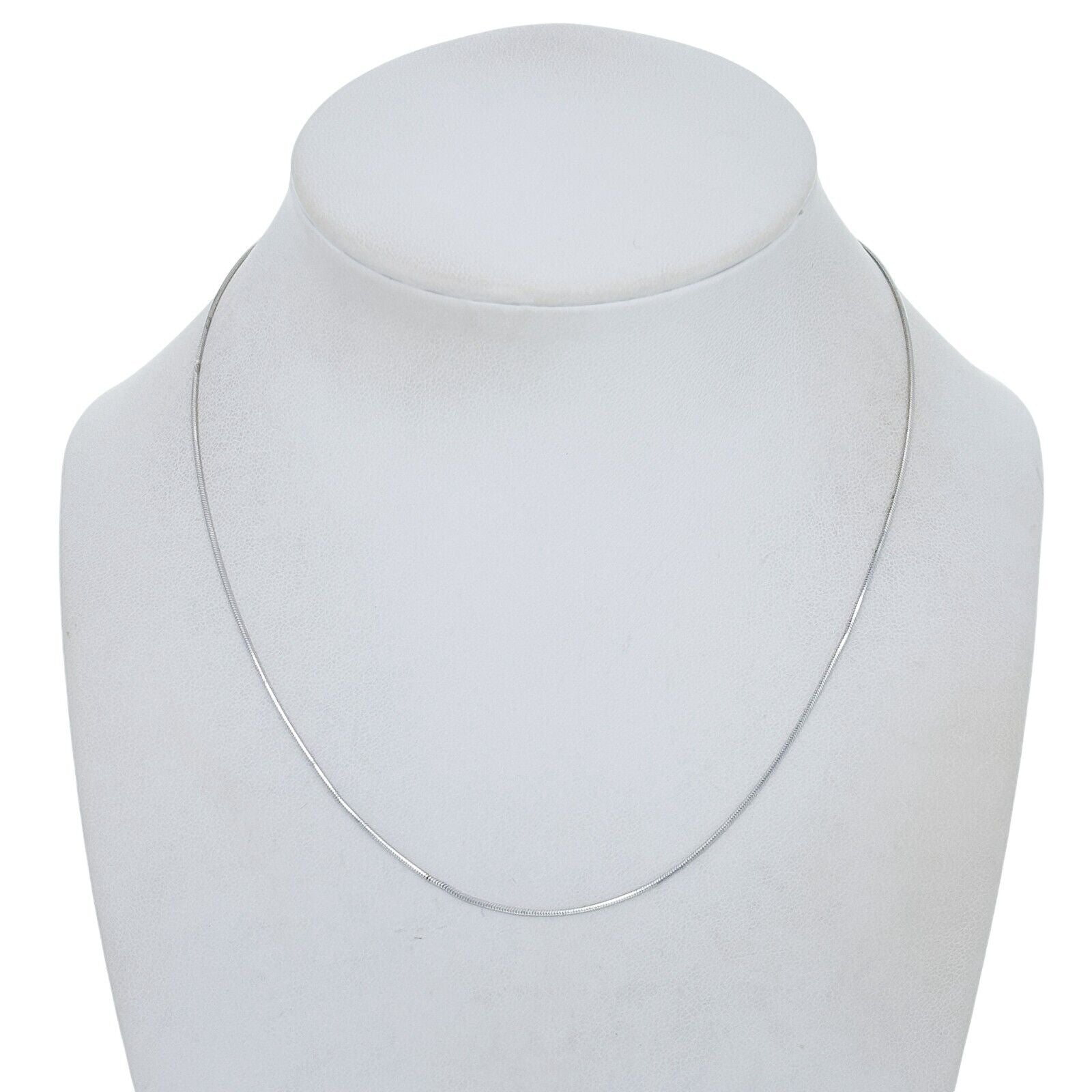 Silver necklace on a mannequin bust against a white background