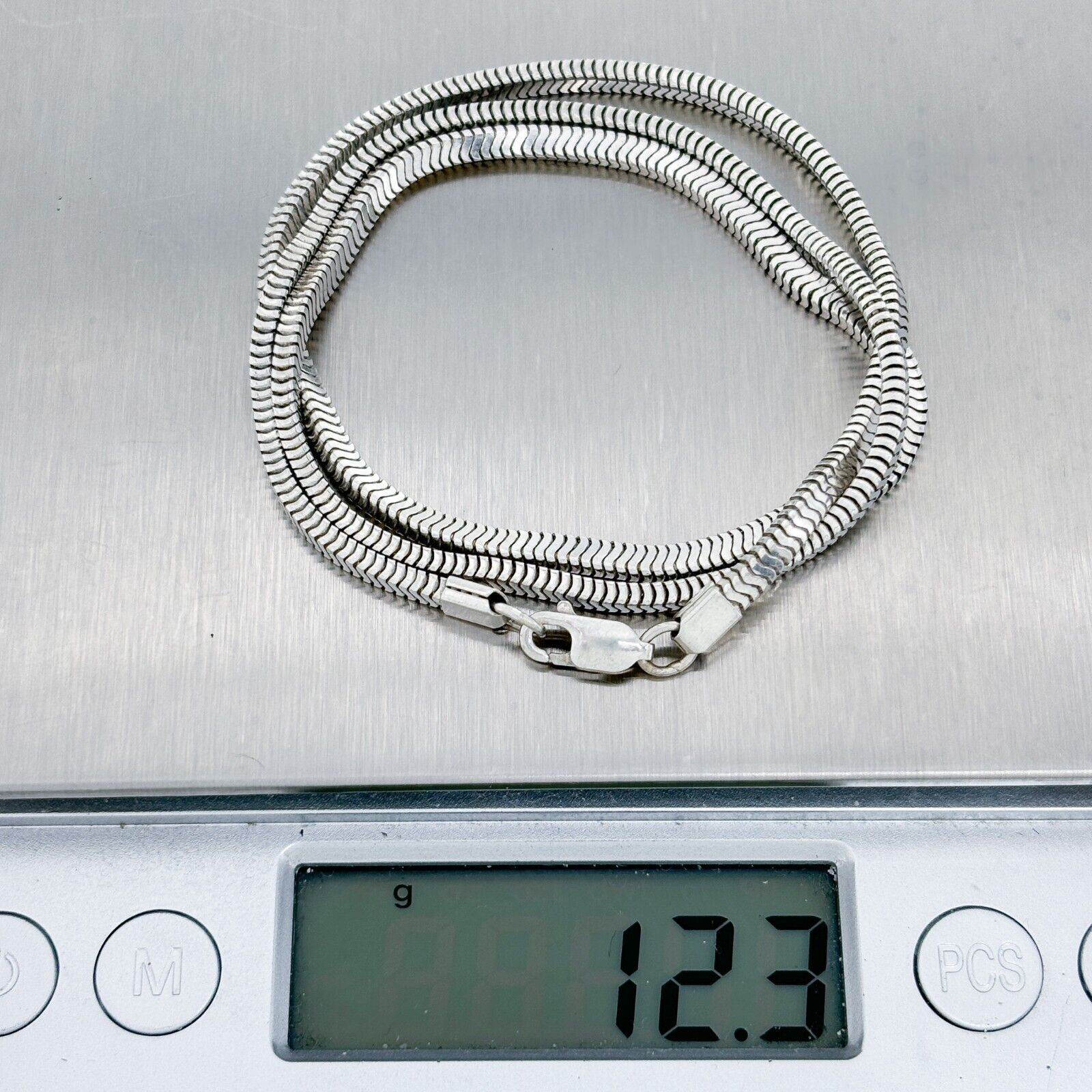 Silver chain necklace on a digital scale displaying weight