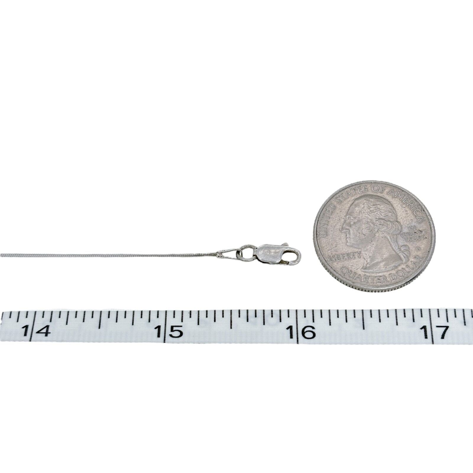 Silver chain with clasp next to a quarter and measuring tape on a white background