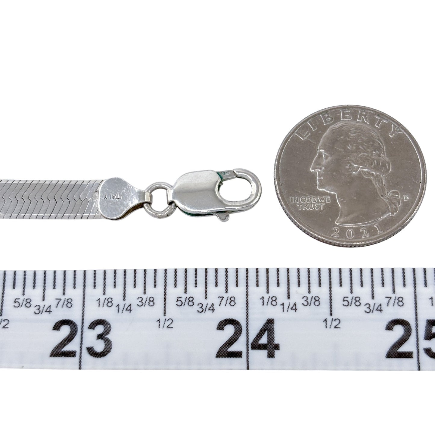 Silver bracelet with clasp next to a quarter and measuring tape on a white background