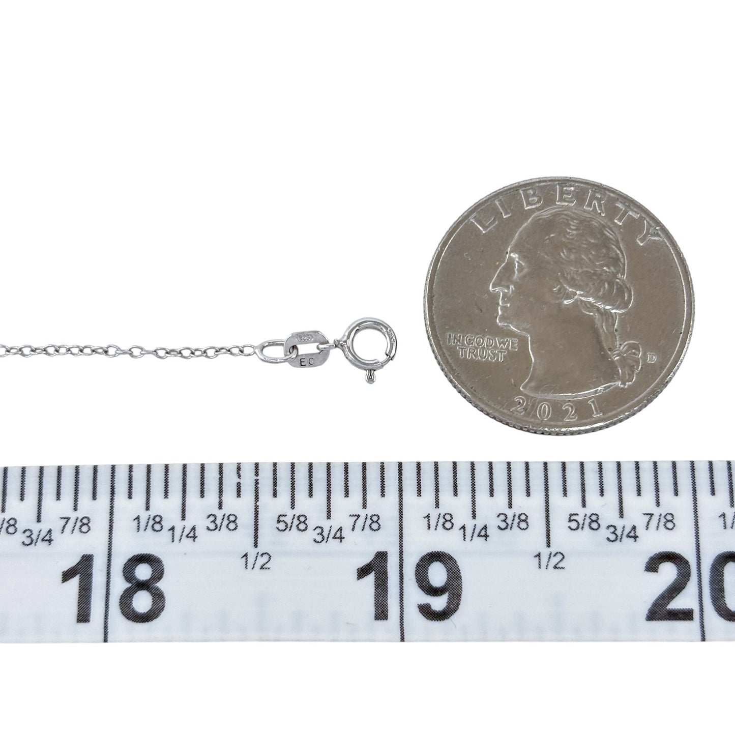 Silver necklace with clasp next to a quarter and ruler for size reference on a white background