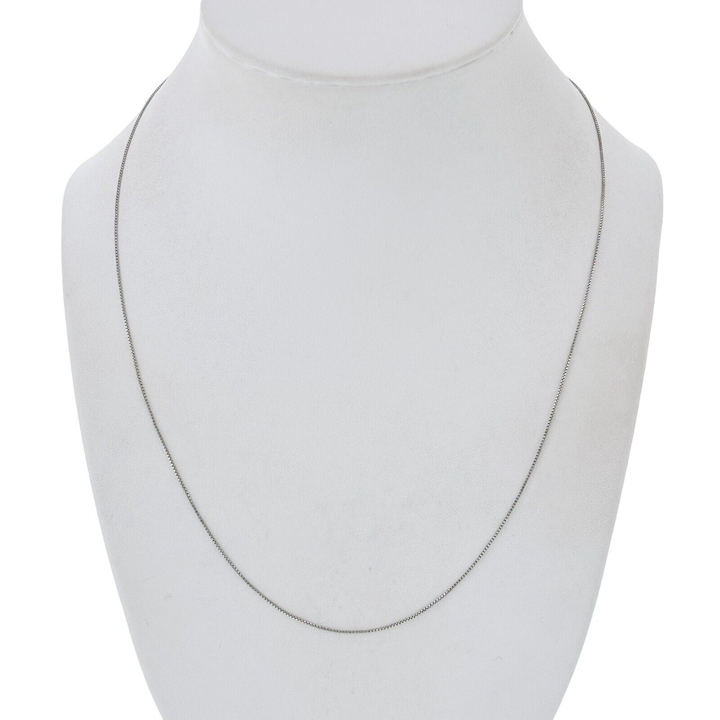 Silver necklace on a mannequin bust against a white background