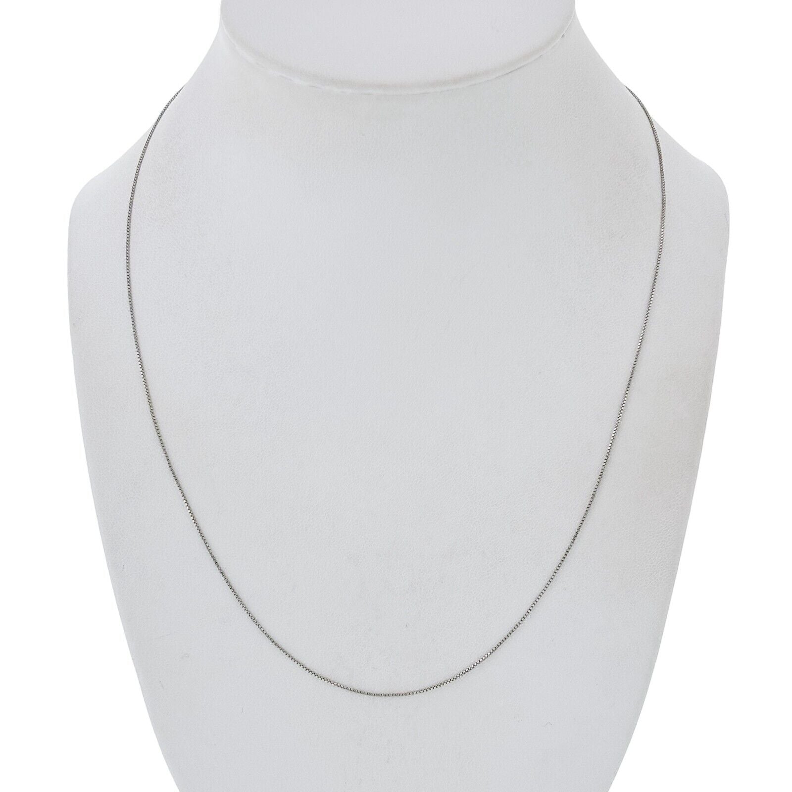 Silver necklace on a mannequin bust against a white background