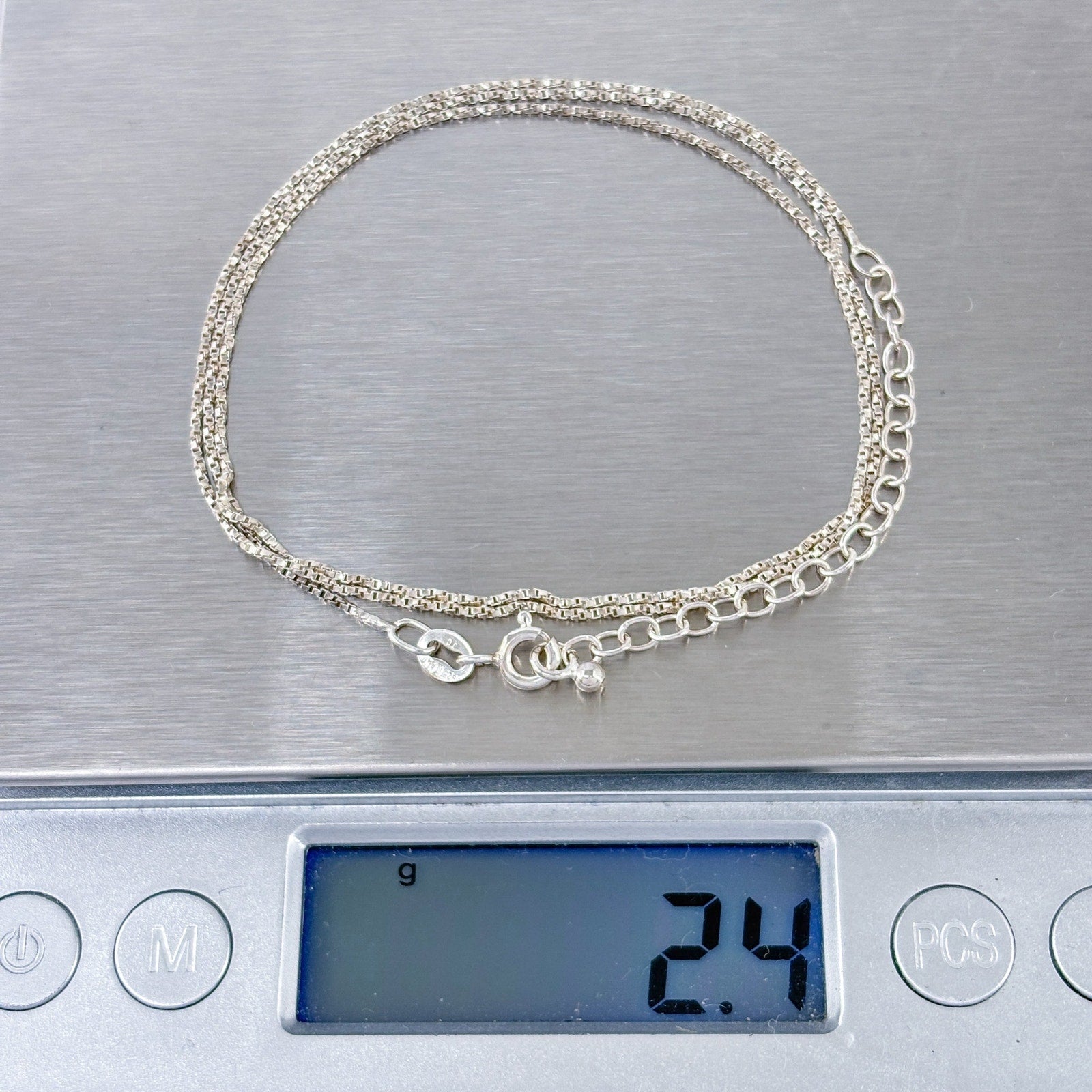 Silver bracelet on a digital scale displaying weight