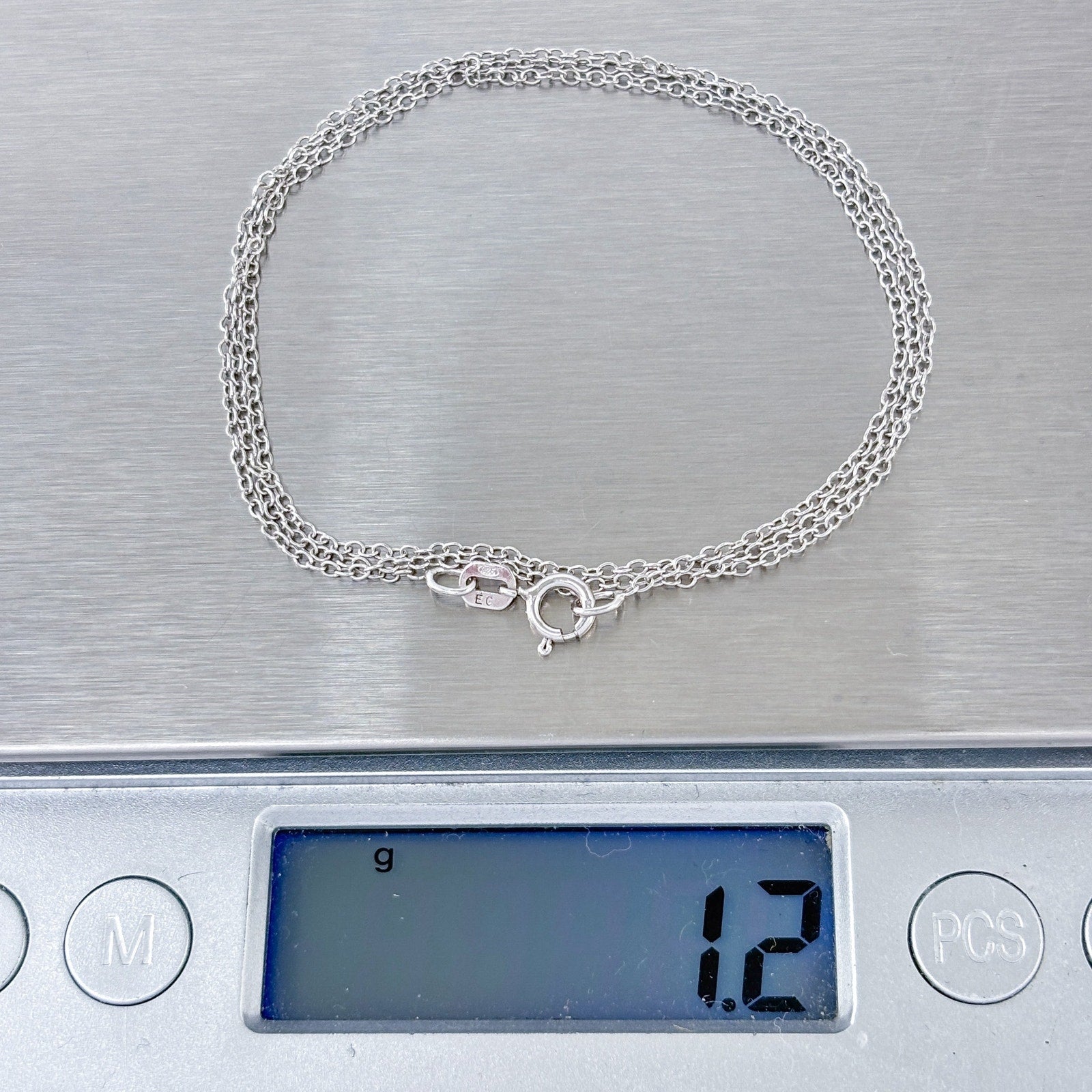 Silver necklace on a digital scale displaying a weight of 1.2 grams.