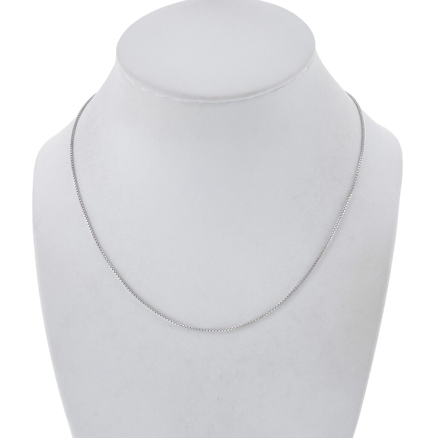 Silver necklace on a mannequin bust against a white background
