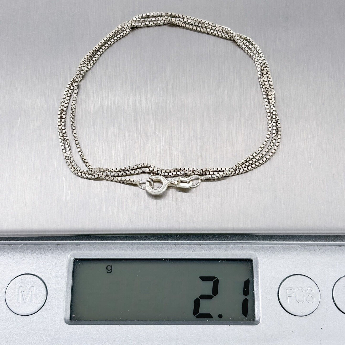 Silver bracelet on a digital scale displaying weight