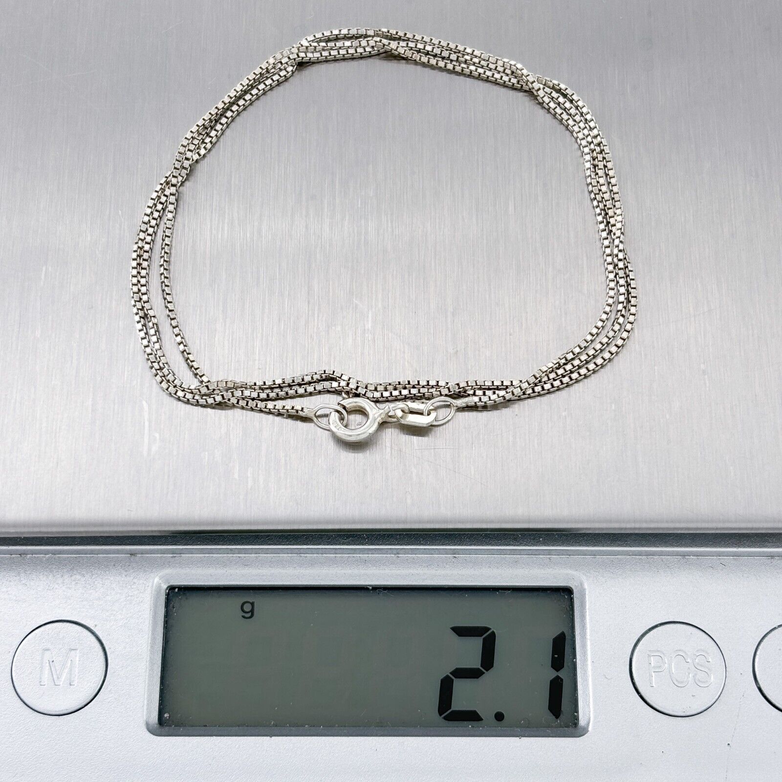 Silver bracelet on a digital scale displaying weight